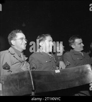 Les cantines Naafi accueillir des troupes US- les travaux de la Marine, l'armée et la Force aérienne Instituts, Angleterre, RU, 1943 Trois soldats américains jouissent d'un show à l'ENSA, NAAFI un quelque part en Angleterre. De gauche à droite : Caporal Roger UN Hoffman (de Fort 495 Carlshad, Californie), le sergent Davy P Porche Jr. (de Slidell, Louisiane) et T/4 Hugo UN Perotti (de 115 3ème place, Brooklyn, New York). Banque D'Images