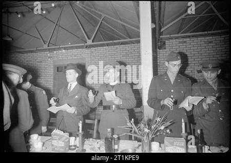 Les Forces alliées célébrer Pâque- traditions juives en temps de guerre La Grande-Bretagne, avril 1944 l'aumônier juif aux Forces (centre) lève son verre comme il parle aux membres des Forces alliées pendant leur repas de Pâque dans une grande salle, quelque part près de Londres. Banque D'Images