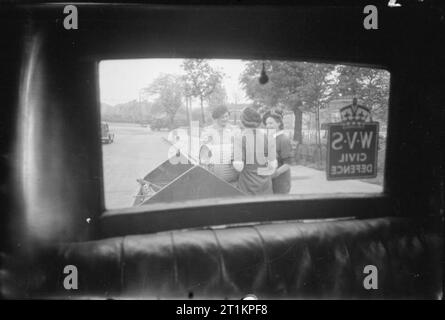 L'alimentation des porcs- Women's Voluntary Service collecte des déchets de cuisine récupérés, East Barnet, Hertfordshire, Angleterre, 1943 vue par la fenêtre arrière de l'unité de collecte de porc WVS voiture, en tant que membres de l'East Barnet vide un cochon bin dans la remorque. Ils sont de gauche à droite : Kathleen Kent (chef de l'unité), Mlle Winifred Jordanie (dos à la caméra) et Mme Gerald de Rivaz. Banque D'Images