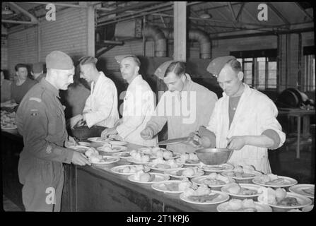 Les Forces alliées célébrer Pâque- traditions juives en temps de guerre La Grande-Bretagne, avril 1944 Les Juifs non-membres de l'Armée de corps indépendants desservent les principaux poissons de cours personnel service juif au cours des célébrations de la Pâque dans un grand hall, quelque part près de Londres. Servir le repas sont (droite à gauche) : Le Sergent E L Hunt, le sergent R Irvine et le sergent J E Lashmar. Sur la gauche est le sergent quartier-maître E Lavande. Banque D'Images