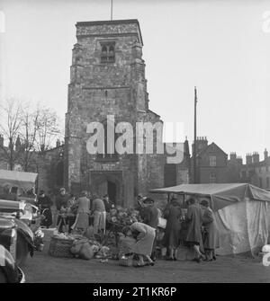 Village autonome- La vie à Hovingham, Yorkshire, Angleterre, octobre 1942 Femmes shop au marché qui a été mis en place à l'extérieur de l'église à Malton, Yorkshire. Les étals sont dirigés par des membres de l'Institut de la femme, ils sont à la vente du surplus de production à proximité Hovingham. Banque D'Images