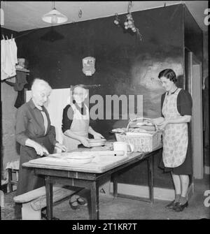 Village autonome- La vie à Hovingham, Yorkshire, octobre 1942 La préparation d'un repas pour ceux qui travaillent dans les champs sont trois générations de la même famille, liée par mariage. De gauche à droite : Mme Harrison (86 ans), Mme Albert Harrison, et sa belle-fille, Mme William Harrison. Banque D'Images