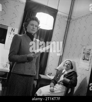 La jeune fille inconnue derrière la bataille de la mer- le travail de Women's Royal Naval Service, 1942 Après un examen médical, Mlle inconnu a été effacée que l'ajustement à entrer dans le dépôt d'instruction WRNS. Nous voyons ici Mlle inconnu avec ses documents de dédouanement, sur le point de quitter la salle pour terminer l'étape suivante du processus. Banque D'Images