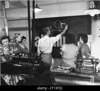 La formation pour le travail de guerre au Chelsea Polytechnic Ministère du travail Centre de formation, Londres, Angleterre, 1941 instructeur à la Ministère du travail Centre de formation de Chelsea Polytechnic dessine un schéma sur le tableau noir pour aider à expliquer quelque chose à un groupe de stagiaires féminines. Banque D'Images