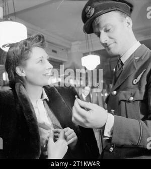 La vie de tous les jours- épouse de guerre en temps de guerre, Londres, mars 1943 Nouveaux fiancés Marcelle Lestrange et Harold Lackland Bevan examiner une bague de fiançailles dans une bijouterie, à Londres. Il y a peu de choix, comme des restrictions des métaux précieux comme l'or et le manque de personnel qualifié pour re-set sonne signifie que des couples comme Marcelle et Harold doit choisir pour la durée du stock d'avant-guerre. Banque D'Images