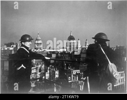 Vous répondre- la production d'un programme radio de la BBC pour les États-Unis d'Amérique, 1941 L'un des panélistes sur 'vous répondre' a été Edward Hulton, propriétaire d'une maison d'édition. Nous voyons ici Hulton (à gauche) et un collègue en feu regarder droit sur le toit de son entreprise Hulton Press. Derrière eux on peut voir la ville de Londres, y compris l'ancien Bailey et la Cathédrale St Paul. Banque D'Images