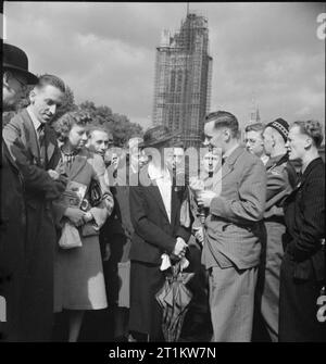 Vous répondre- la production d'un programme radio de la BBC pour les États-Unis d'Amérique, 1941 dans le cadre d'un programme intitulé "Rencontre avec Jean Pierre82', nous voyons ici Thomas Vaughan Wynford correspondant demande à Mme Galraith, membre du public, une question. Ils sont entourés d'une foule de passants, dont Leslie Hancock, un soldat d'un régiment écossais, tous intéressés à la réponse de Mme Galraith. L'entrevue a lieu à Victoria Gardens sur Victoria Embankment et derrière eux, une partie des chambres du Parlement peut être vu, couvert d'échafaudages. Cette photographie a probablement été Banque D'Images