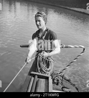 Les femmes dirigent un bateau- La Vie à bord de la Barge Canal 'Heather Bell', 1942 Miss Mars tenir sur une corde comme elle se tient à la barre à bord du 'HEATHER BELL'. Banque D'Images