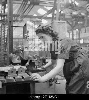 Usine de femmes le travail de guerre au centre de formation de Slough, Angleterre, Royaume-Uni, 1941 Ruby peut fonctionne sur une machine, sans doute une scie mécanique, à Slough centre de formation. Banque D'Images