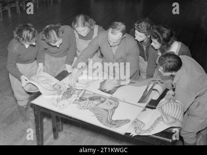 L'instruction de l'Armée de terre de femmes, probablement à la ferme de Cannington, Somerset, Angleterre, C 1940 Un groupe de membres de la Women's Land Army entourent leur professeur comme ils écoutent un exposé sur l'anatomie du cheval. Sur la table en face d'eux sont des diagrammes de diverses sections d'un cheval, montrant les os, muscles et organes. Banque D'Images