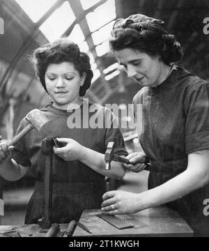 Usine de femmes le travail de guerre au centre de formation de Slough, Angleterre, Royaume-Uni, 1941 Sally Schwartzman et Ruby peut utiliser des marteaux pour travailler sur les charnières et d'autres raccords à Slough centre de formation. Banque D'Images