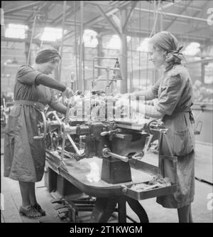 Usine de femmes le travail de guerre au centre de formation de Slough, Angleterre, Royaume-Uni, 1941 Deux femmes régler l'étrave la machine à Slough centre de formation. Banque D'Images