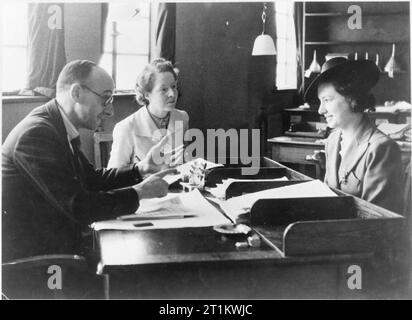 Usine de femmes le travail de guerre au centre de formation de Slough, Angleterre, Royaume-Uni, 1941 Betty Pridie (sur la droite) reçoit quelques conseils de la part de sa femme comme superviseur et un autre membre du personnel de l'échange d'emploi à Slough centre de formation. Banque D'Images