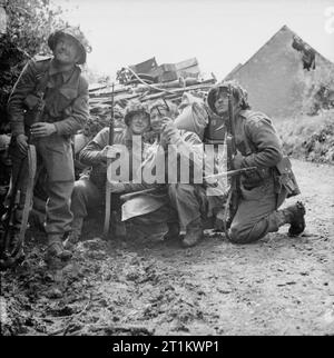 L'Armée britannique en Normandie 1944 hommes du 2e Régiment de Kensington, 49e Division (West Riding), tenter de repérer un sniper dans Rauray lors de l'opération "Epsom", 28 juin 1944. Banque D'Images