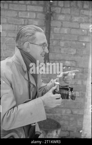 YMCA snapshots from Home- Civilian Photographers at Work, UK, 1944 Un portrait du photographe amateur souriant E Gordon Miller qui donne une dernière instruction à son sujet (non photographié) avant de prendre la photo. M. Miller vient de Liverpool. Banque D'Images