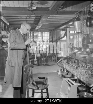 YMCA instantanés de la maison - photographes civils au travail, Royaume-Uni, 1944 Ironmonger Bernard Pinder prépare son appareil photo pour une après-midi dans son magasin de Market Square, Salisbury, Wiltshire. Il est midi un samedi, et la boutique a fermé pour la journée, permettant à M. Pinder de consacrer le reste de la journée à la photographie. Banque D'Images