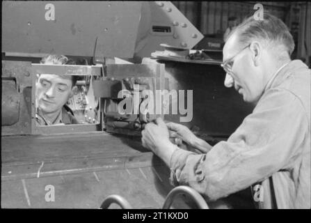 Naissance d'un British Tank- Production Réservoir en Angleterre, 1941 travailleurs de l'usine monter le pare-soleil en place sur cette Crusader, quelque part en Angleterre, 1941. Banque D'Images