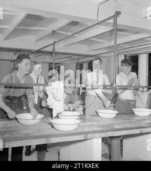 Blitz Repair Squad's Camp Londres- la vie quotidienne avec les équipes de réparation Blitz, Londres, Angleterre, RU, 1944 Les constructeurs de l'équipe de réparation 'Blitz' profiter d'un matin se laver et se raser à bassins dans les ablutions abris qui font partie de leur camp dans le carré d'Onslow. Banque D'Images