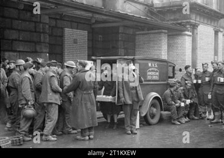 Cantine Blitz- les femmes du Women's Voluntary Service Exécuter une cantine mobile à Londres, Angleterre, 1941 Patience 'Boo' Marque et Rachel Bingham servir le thé à des hommes du Royal Engineers de l'arrière d'un véhicule plateau WVS, a fait don à la WVS par la Croix-Rouge américaine. Les Royal Engineers a été construire des ponts dans les cratères de bombes dans les artères principales. Cette photographie a été prise quelque part à Londres en 1941. Banque D'Images