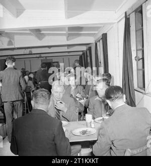 Blitz Repair Squad's Camp Londres- la vie quotidienne avec les équipes de réparation Blitz, Londres, Angleterre, RU, 1944 Les constructeurs de l'équipe de réparation 'Blitz' Profitez d'un copieux petit-déjeuner dans leur désordre hut in London's Onslow Square avant de commencer leur journée de travail. La légende originale membres qu'ils n'ont d'attente pour un petit déjeuner de "bulle et grincent plus minute partie de bacon haché, du pain, de la margarine, de la confiture et du thé". Banque D'Images