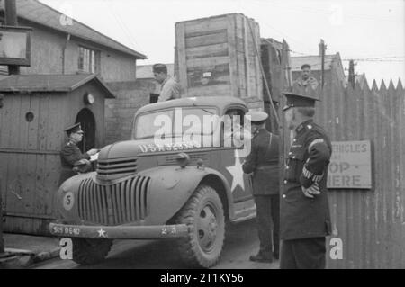 Produits britanniques en gares de triage- anglo-américain la coopération en temps de guerre La Grande-Bretagne, 1943 La police britannique vérifier un camion-charge de tous les équipements de la qu'il nous laisse un triage, quelque part en Grande-Bretagne, sur la voie d'une unité voisine. Faisant partie de l'expédition sont les pneus, l'huile de lubrification, les radiateurs et les déchets de coton. Conduire le camion est Walter Pfc Toye de couverture 4609 Street, Philadelphie. Banque D'Images