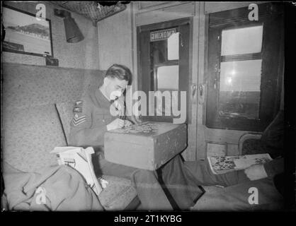 British Railways en temps de guerre -- Transports Train Laisser entre Londres et l'Écosse, au Royaume-Uni, en 1944, dans un compartiment fumeurs dans un train voyageant entre Londres et l'Ecosse, un sergent de la Royal Air Force s'installe à un puzzle pour passer le temps sur le voyage. Il est à l'aide de l'espèce comme une table sur laquelle répartir les pièces de puzzle. Banque D'Images