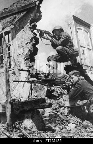 L'armée russe au cours de la Seconde Guerre mondiale les troupes russes posent avec leurs armes automatiques dans les ruines d'un village russe. Deux sont armés de PPSh-41 sous les mitrailleuses, et le troisième a une mitrailleuse légère Degtyaryov. Banque D'Images