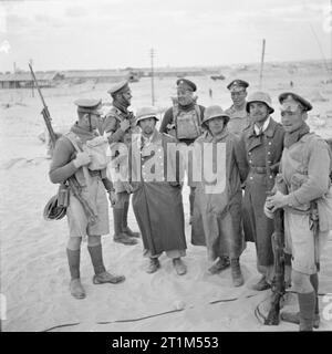 L'Armée britannique en Afrique du Nord en 1941, la première armée allemande prisonniers capturés dans le désert occidental sous la garde de soldats britanniques, 17 avril 1941. Banque D'Images