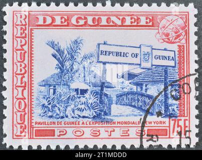 Timbre-poste annulé imprimé par la Guinée, qui montre Guinea Pavilion, exposition universelle de New York, exposition universelle de New York, vers 1964. Banque D'Images
