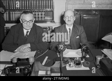 Personnalités politiques britanniques 1936-1945 l'Administration Attlee 1945 - 1951 : Le Premier Ministre Clement Attlee (droite) et Ministre des affaires étrangères Ernest Bevin photographié au 10 Downing Street à minuit le 14 août 1945. Ils avaient tout juste d'annoncer, dans un discours diffusé à la Grande-Bretagne et l'Empire, la nouvelle de la reddition du Japon. Banque D'Images