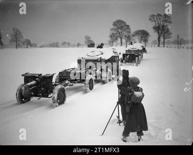 L'armée polonaise dans le Royaume-Uni, anti-aériens 1940-47 équipe mitrailleuse Bren monte la garde comme 4,5 pouces obusiers du 1er Régiment d'artillerie lourde (1e corps polonais), tractées par Morris-Commercial 'Quad', en passant par les tracteurs d'artillerie dans la neige profonde, l'Écosse. Banque D'Images