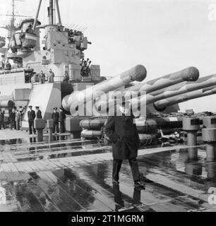 Winston Churchill à bord du cuirassé HMS Prince de Galles au cours de son voyage en Amérique du Nord pour rencontrer le président Roosevelt, août 1941. Le Premier ministre britannique Winston Churchill à bord du HMS Prince de Galles au cours de son voyage en Amérique du Nord pour rencontrer le président Roosevelt. La chambre quadruple 14 canons de tourelle Y est visible en arrière-plan. Banque D'Images