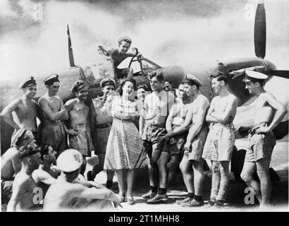 Paula Green réceptions à Rajaliya HMS, dans l'Extrême-Orient, juin 1945. Mlle Paula Green, le chanteur de radio né Blackpool donne une chanson pendant 'facile' à l'entretien évaluations à RAJALIYA, une jungle HMS Royal Naval Air Station, une partie de la flotte des Indes britanniques. Le Seafire ils sont l'entretien constitue l'arrière-plan. Banque D'Images