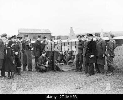 Les cadets de l'air apprendre les bases du vol à St Merryn RNAS à Cornwall, en février 1944. Flight Lieutenant Birabangse, bien connu en temps de paix comme l'automobiliste course B Bira, mais maintenant instructeur-chef à l'école, montre un cadet comment gérer les commandes d'un planeur élémentaire. De gauche à droite : Sous lieutenant (A) W A Murray, RNVR, un instructeur ; le lt cdr (K) Un Garston-Jones, RNVR, Chef des liaisons vers l'ATC pour HMS Vulture, chef d'Escadron Sir John Mclesworth St Aubyn ; le Commodore de l'air W Sawrey ; le lieutenant Biribangse vol Prince, le Capt W P McCarthy, RN, commandant du HMS Vulture. Banque D'Images