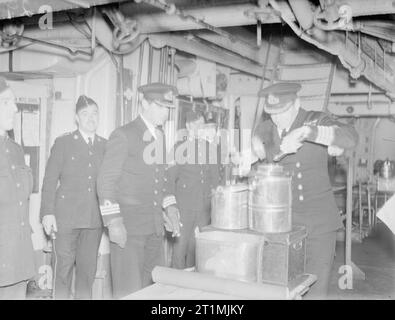 Les Royal Marines. Avec les Royal Marines de la Home Fleet, octobre et novembre 1942. Captain's 'tours'. Le capitaine de l'HMS cruiser, Cumberland, l'inspection pour le mess sur le messdeck Marines', ou 'barracks', comme les Marines eux-mêmes préfèrent l'appeler. Même aujourd'hui, le 'barracks' sont généralement situés entre les quartiers des officiers et les seamens' messdecks, une survie de la fois lorsque l'une des principales responsabilités des Marines a été d'agir en tant que policiers et de préserver la discipline à bord. Banque D'Images