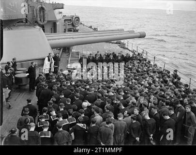 La Royal Navy pendant la Seconde Guerre mondiale, un service commémoratif pour les marchands de Jervis Bay Cruiser armés, se tiennent sur le pont supérieur du HMS RODNEY tandis qu'elle est en mer. Relativement peu ont été en mesure d'assister le service, le reste étant à leurs postes, certains étant dans les tourelles de canons de 16 l'on voit dans l'image. Banque D'Images