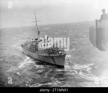 La Royal Navy pendant la Seconde Guerre mondiale, le lancement du moteur de secours, ML 536, après avoir été pris en remorque par le porte-avions d'Escorte HMS EMPRESS pour la deuxième fois. Un fil de 5,5 pouces et de 6 pouces de corde de chanvre a été adopté. Banque D'Images