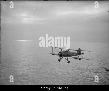 La Royal Navy pendant la Seconde Guerre mondiale Peu de temps après la chute d'une torpille factice, un Fairey Swordfish avion tours pour un accueil dans les étapes finales d'un programme de formation flightover la côte écossaise de Crail. Banque D'Images