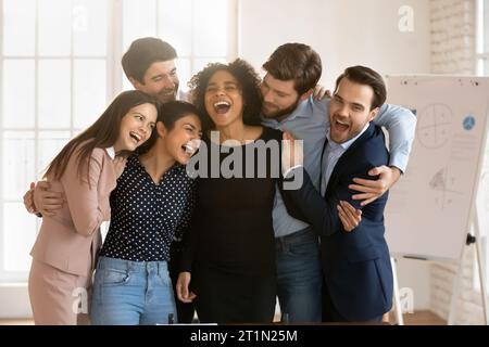 Joyeux et excités amis de bureau multiethniques célébrant le succès du travail d'équipe Banque D'Images