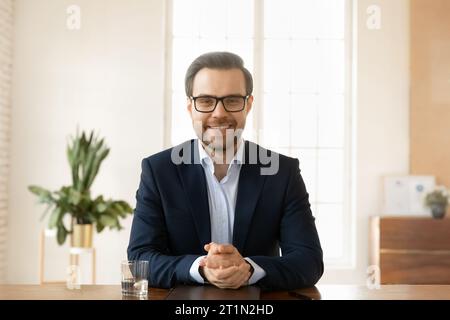 Confiant positif bel homme d'affaires dans les lunettes regardant la caméra Banque D'Images