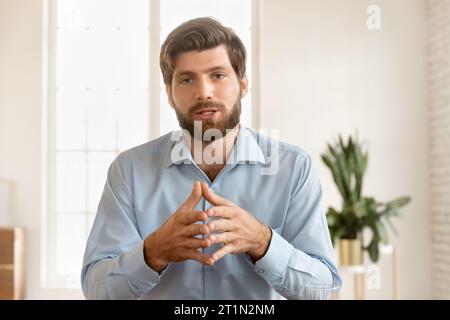 Sérieux beau jeune blogueur d'affaires homme parlant à la caméra Banque D'Images