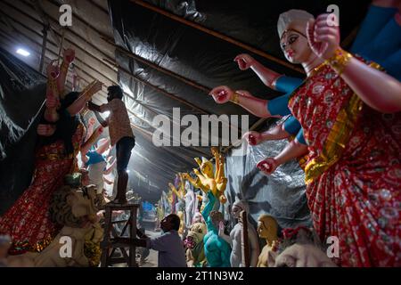 New Delhi, Inde. 14 octobre 2023. Un artiste est observé ornant l'idole d'argile de la déesse Durga en préparation du prochain festival Durga Puja au temple Sarojini Nagar Kalibari. Durga Puja est un festival hindou célébré principalement dans le Bengale occidental et par les communautés bengales du monde entier. C'est une célébration de plusieurs jours dédiée à la déesse Durga, symbolisant le pouvoir féminin divin et la victoire du bien sur le mal. (Photo Pradeep Gaur/SOPA Images/Sipa USA) crédit : SIPA USA/Alamy Live News Banque D'Images