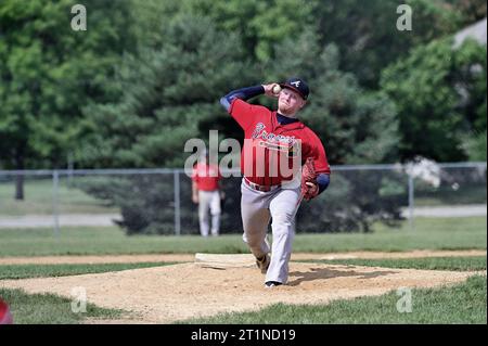 Spring Grove, Illinois, États-Unis. Lanceur livrant un terrain à un batteur en attente pendant un match de baseball amateur masculin dans la banlieue de Chicago. Banque D'Images