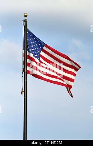 Streamwood, Illinois, États-Unis. Un drapeau américain se déploie dans la brise sur un mât à un mémorial des anciens combattants dans une banlieue de Chicago. Banque D'Images