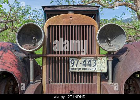 La calandre et les phares vides d'une voiture antique rouillée en Colombie-Britannique, Canada Banque D'Images