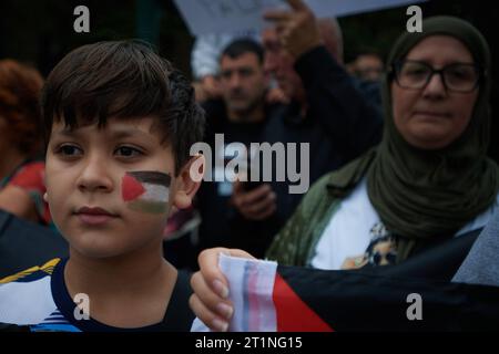 Pamplona, Espagne. 14 octobre 2023. Un enfant palestinien a le drapeau de Gaza peint sur son visage pendant la manifestation. Des centaines de manifestants se sont rassemblés à Pampelune en solidarité avec les attaques israéliennes contre la population de Gaza. Crédit : SOPA Images Limited/Alamy Live News Banque D'Images