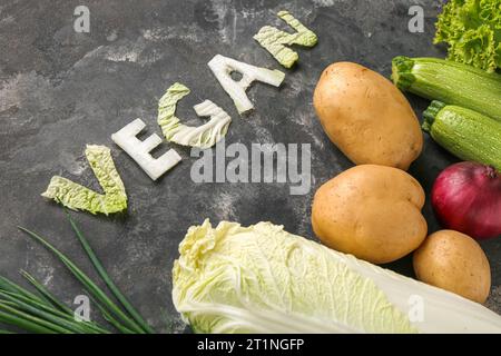 Mot VEGAN fait de chou et de différents légumes frais sur fond noir Banque D'Images