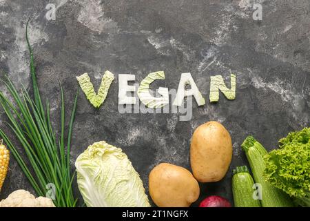 Mot VEGAN fait de chou et de différents légumes frais sur fond noir Banque D'Images