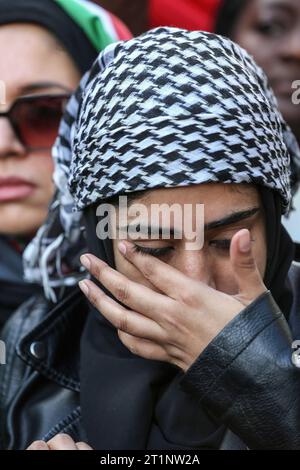 Londres, Royaume-Uni. 14 octobre 2023. Une manifestante essuie une larme en écoutant des discours à Whitehall. Des groupes se sont réunis pour marcher jusqu'à Downing Street pour soutenir le peuple palestinien avant les représailles israéliennes après la récente attaque du Hamas contre des civils israéliens. Pour tenter de dissiper les tensions, le Ministre de l ' intérieur a rappelé aux policiers qu ' agiter des drapeaux palestiniens et utiliser des chants et des slogans pourrait contrevenir à la loi sur l ' ordre public. Crédit : SOPA Images Limited/Alamy Live News Banque D'Images