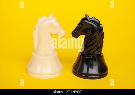 Vue sélective des échecs de chevalier se déplaçant vers pour la bataille avec fond de couverture jaune. Stratégie et concept tactique Banque D'Images